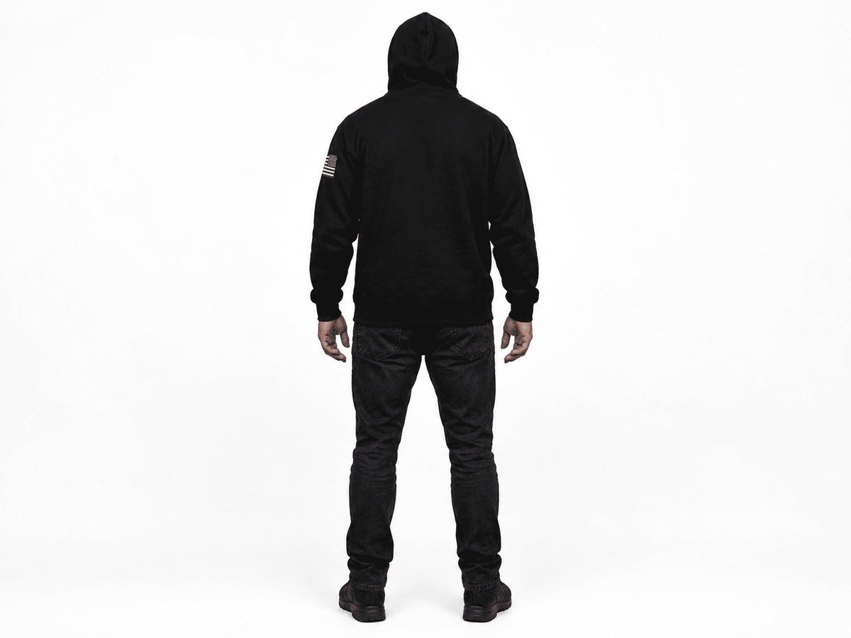 A person viewed from the back wearing a black hooded sweatshirt and black pants against a plain white studio background.